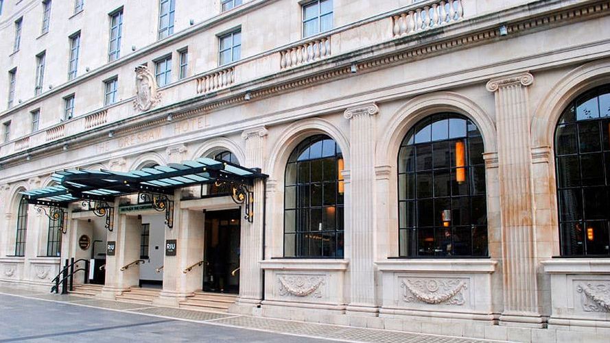 Historische Fassade des The Edwardian Manchester Hotels mit klassischer Steinarchitektur, großen Rundbogenfenstern und einem eleganten Vordach über dem Hoteleingang | © RIU