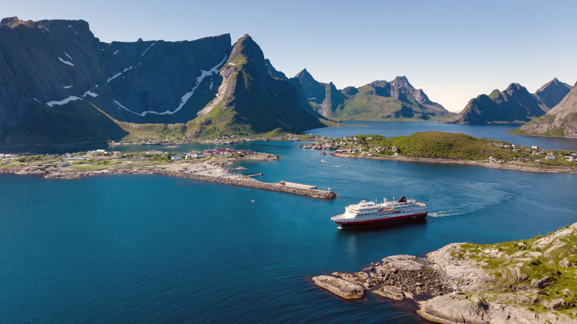 Luftaufnahme der MS Finnmarken segelnd in Reine, Lofoten | © Hurtigruten