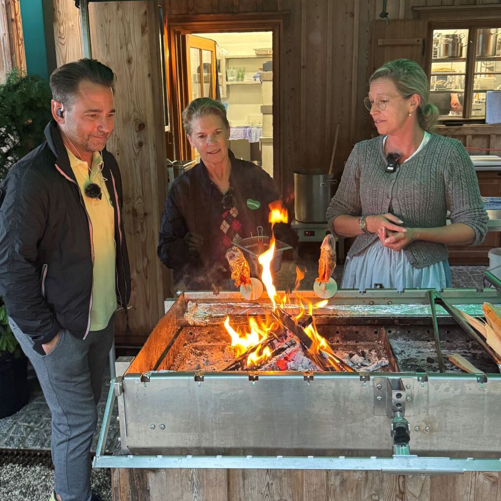 Dennis Willms, Cornelia Poletto und Die Wirtin der Seewiese beim Steckerlfisch zubereiten.